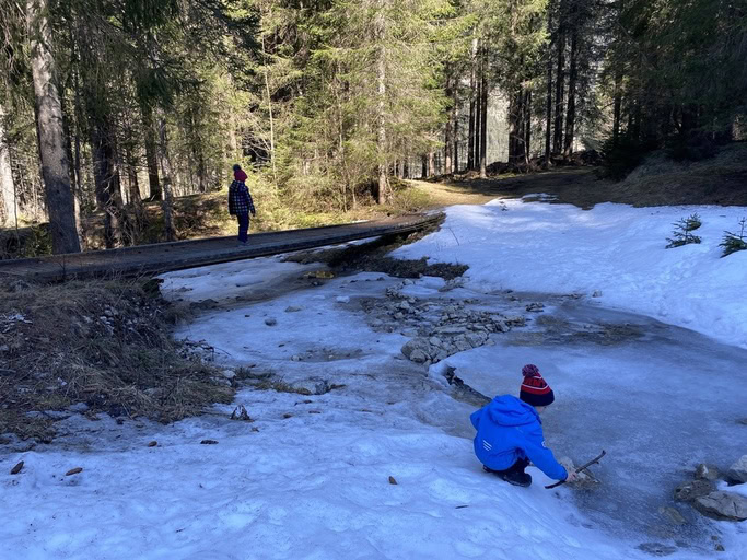 Kinder spielen am Wasser am Auerwasserfall in Bichlbach in Tirol