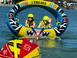 Im seaSports Wassersportcenter XO XTREME Reifen lassen sich zwei Jugendliche auf dem Wasser über den Bodensee ziehen
