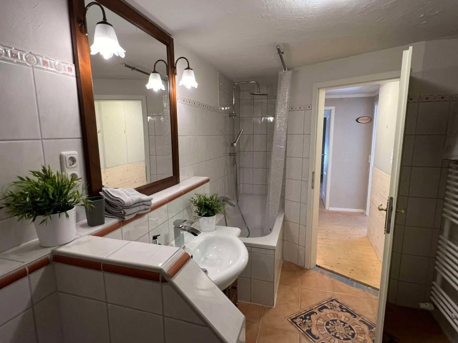 Badezimmer mit Duschwanne und Waschbecken und Klo im Ferienhaus Beim Patzelt in Nesselwang