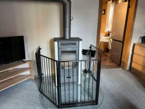 Ofen im Ferienhaus Beim Patzelt mit Ofengitter aussenrum für Kinder