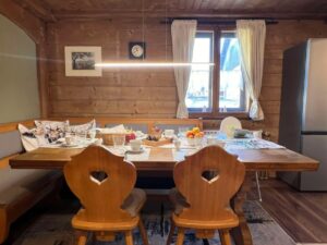 Gedeckter Frühstückstisch im Ferienhaus Patzelt in Nesselwang in der Stube mit gepolsterter Eckbank und rustikalen Bauernstühlen
