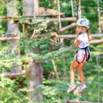 Mädchen hängt an einer Zipline im AbenteuerPark Kressbronn am Bodensee