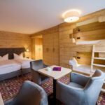 der Blick ins Zimmer mit Ehe- und Stockbett im Hotel Bannwaldsee in Halblech